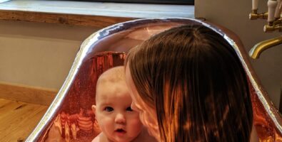 A lady with her child in a gleaming Copper Bathtub